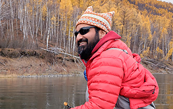 Dr. Sudeep Chandra at a lake, working in the field.